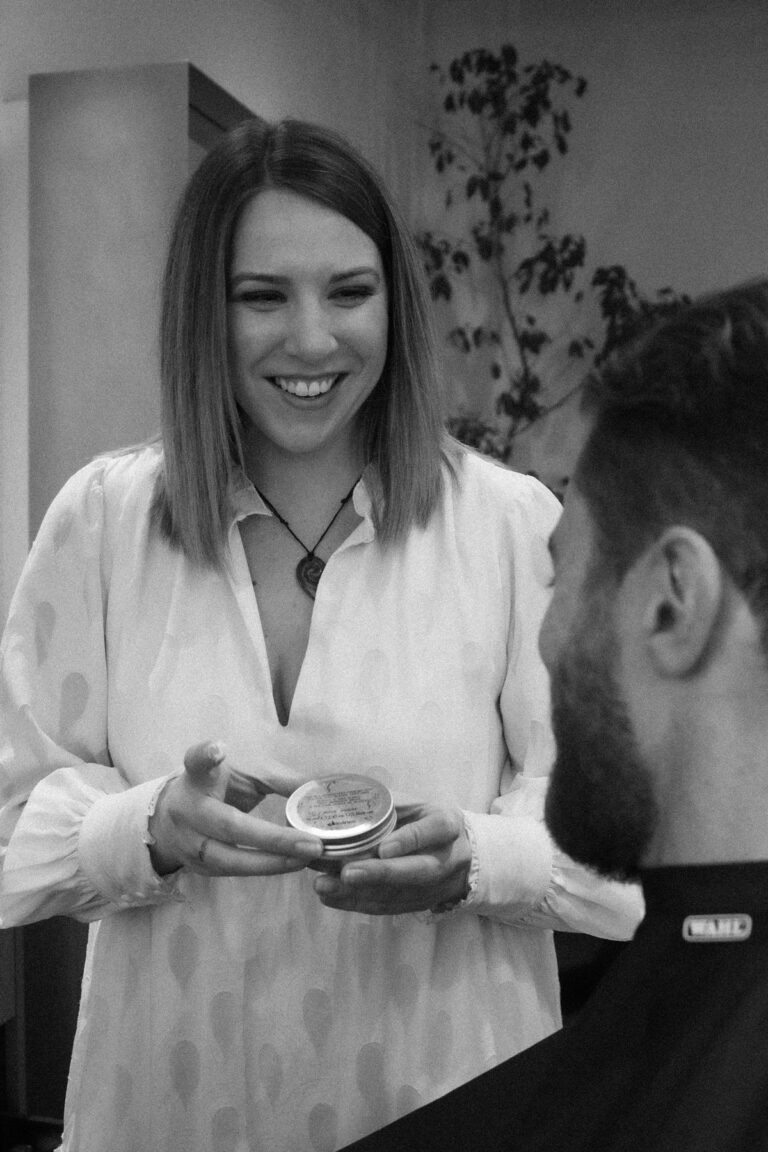 Lydia, a master stylist hairdresser at Stravinski,j showing a client a Davines hair care product.